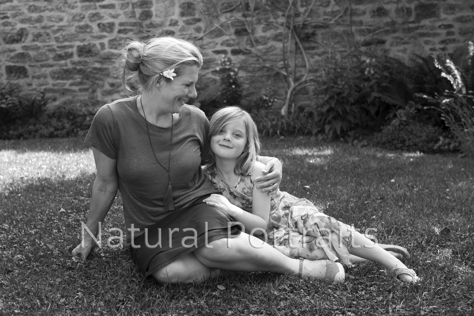 mother and daughter sitting on grass