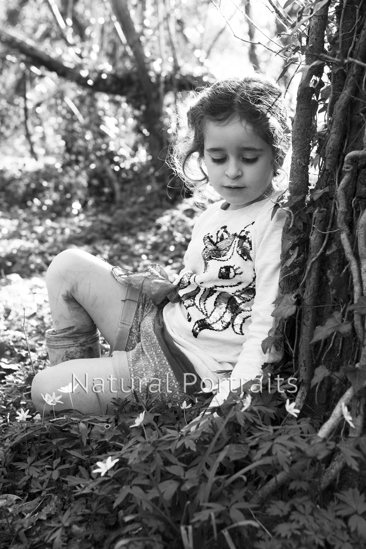 girl looking at flowers in wood photo